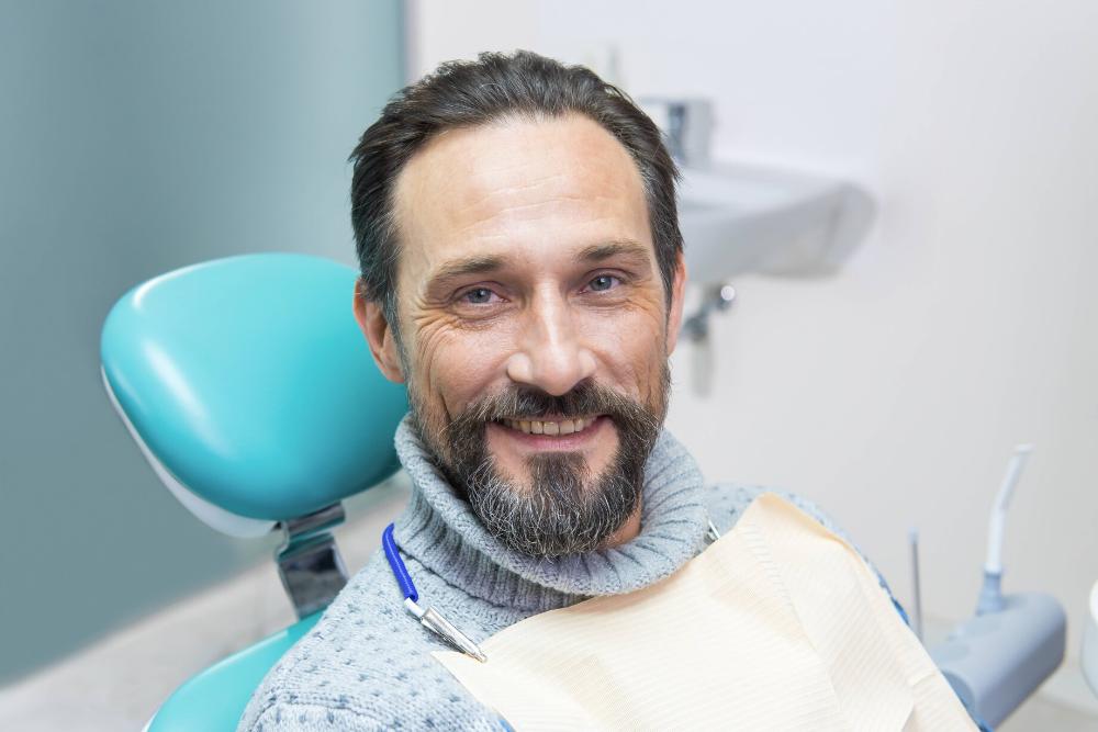 man smiling in dental chair in dunedin