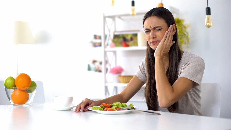 emergency dentist dunedin | woman holding her jaw from tooth pain