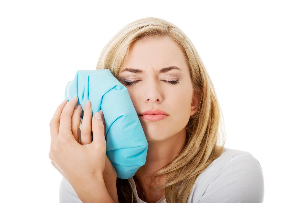 woman holding ice pack to jaw