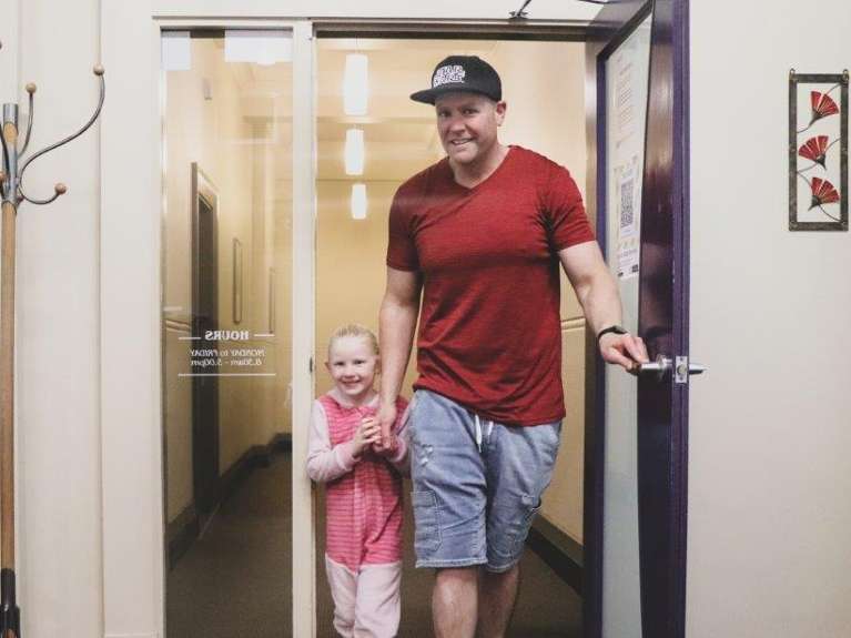 Father and child walking out the door of dentist near me Dunedin NZ 9016