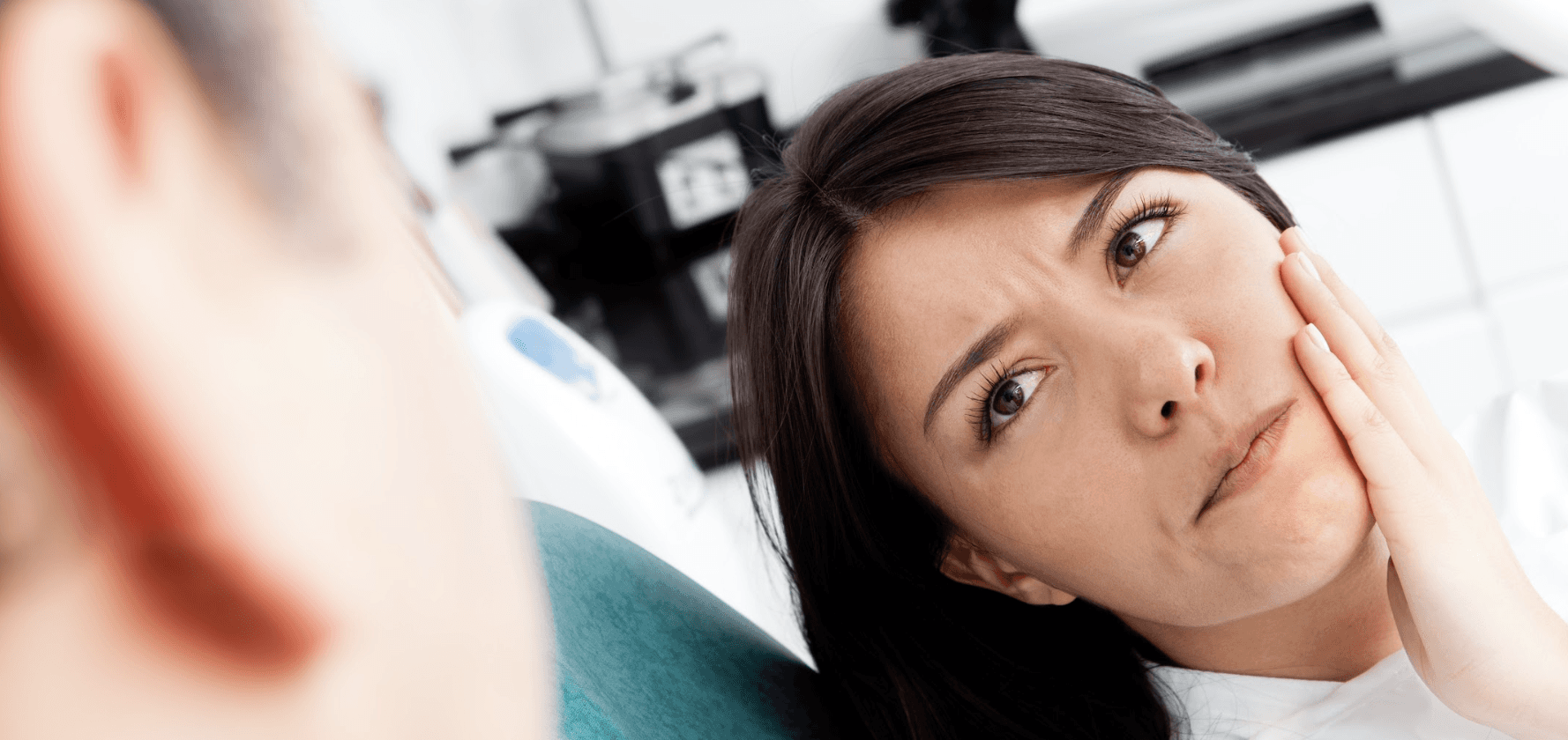 woman holding her jaw from pain during a dental emergency 