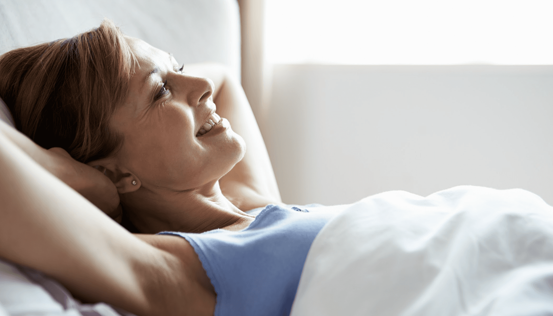woman relaxing in bed after a tooth extraction