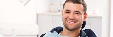 Dunedin man smiling while sitting in a dental chair