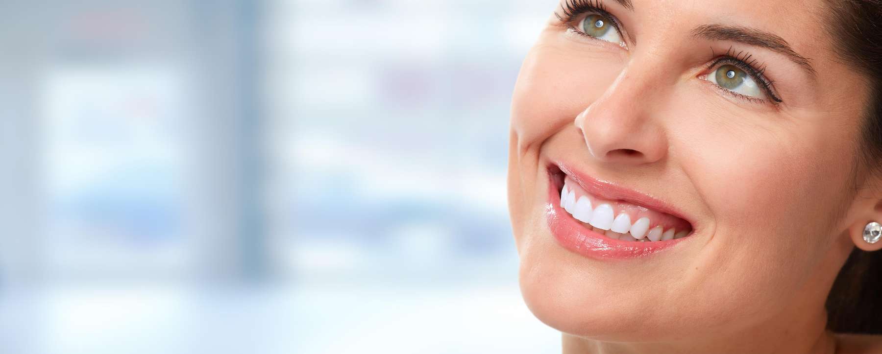 Woman with dental bridge looking up smiling at dentist in Dunedin, Otago