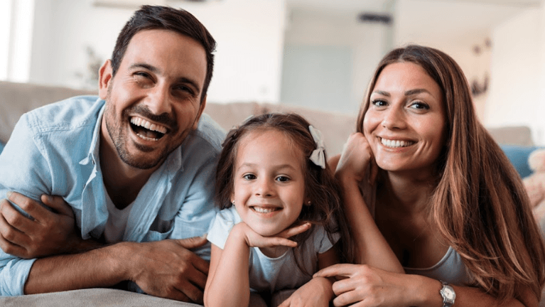 Family smiling in waiting area at dentist in Dunedin, Otago